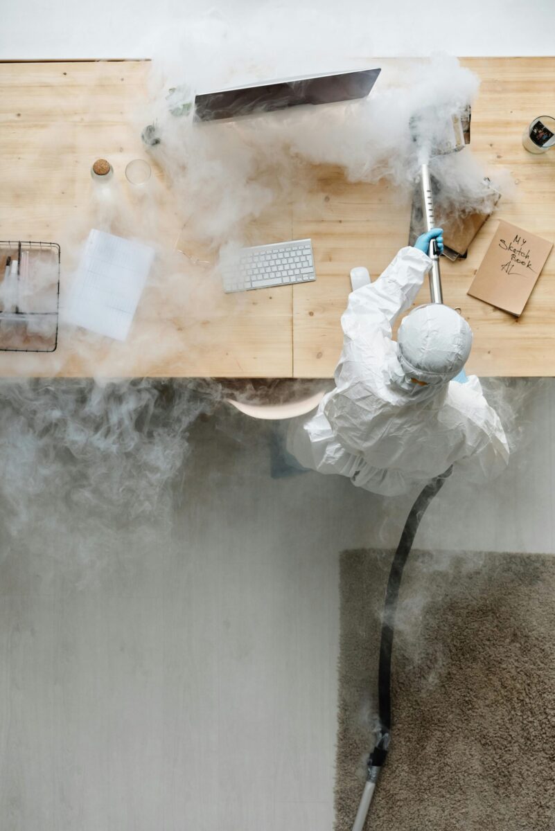 Electrician wearing safety gear operates switchboard in industrial setting.